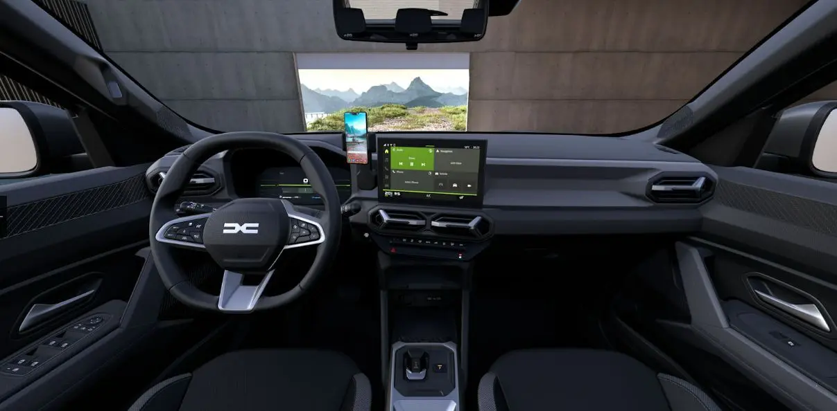 Vue intérieure avant du Dacia Duster 2026 gris schiste, tableau de bord moderne avec écran central tactile et volant multifonction.