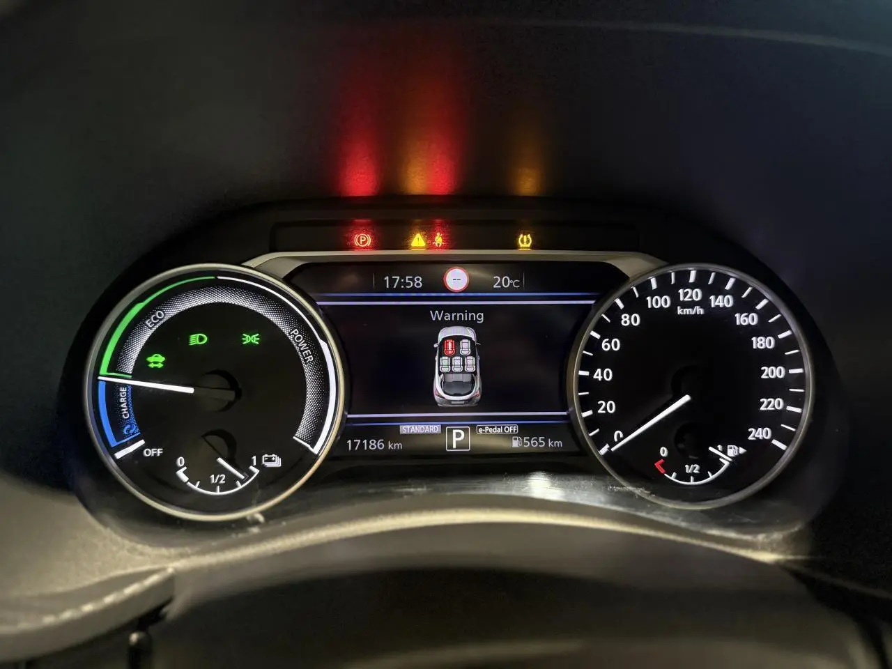 Tableau de bord du Nissan Juke Hybrid 2024 montrant les compteurs et un avertissement de porte ouverte.