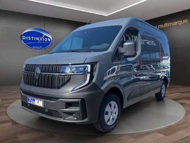 Renault Master gris urbain en 3/4 avant droit, avec calandre noire distinctive et roues blanches.