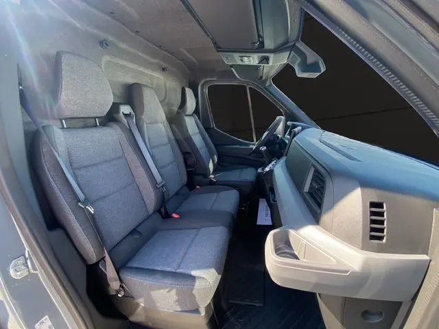 Gros plan sur la poignée intérieure et les commandes de lève-vitres côté conducteur du Renault Master gris urbain.