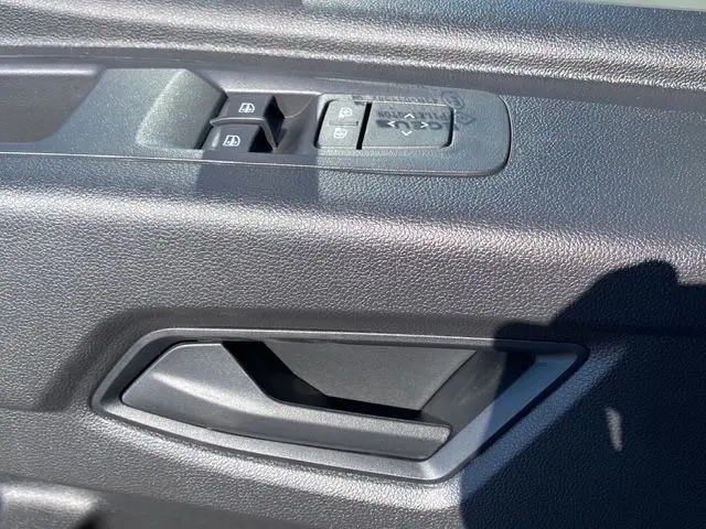 Vue intérieure côté gauche du Renault Master 2025, montrant la banquette passager grise avec surpiqûres bleues et tableau de bord gris.