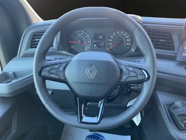 Vue rapprochée du volant gris avec commandes intégrées et tableau de bord du Renault Master 2025.