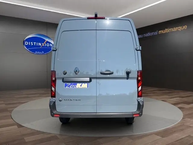 Vue arrière d'un Renault Master gris urbain 2025 avec portes arrière tôlées et feux rouges verticaux.