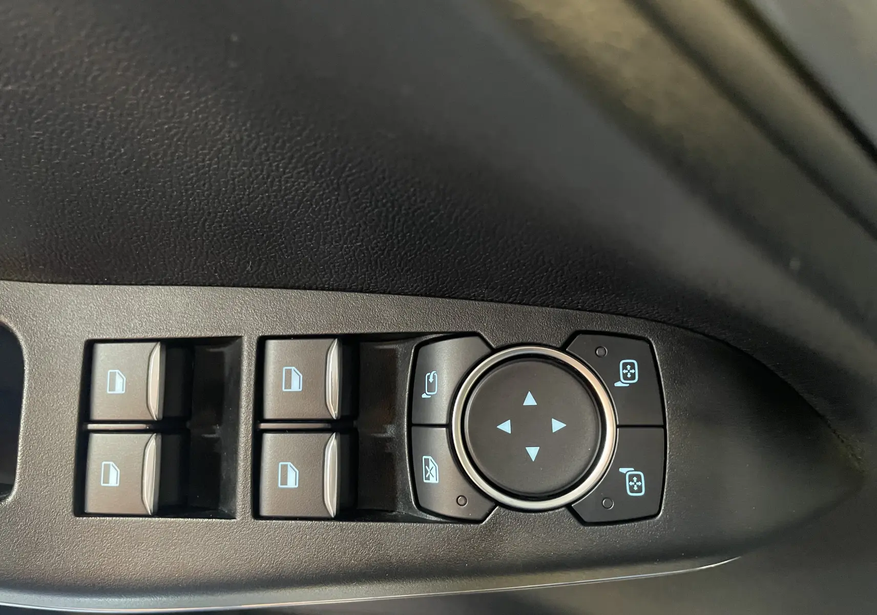 Commandes électriques des vitres et réglages des rétroviseurs côté gauche dans une Ford Puma gris 2020.