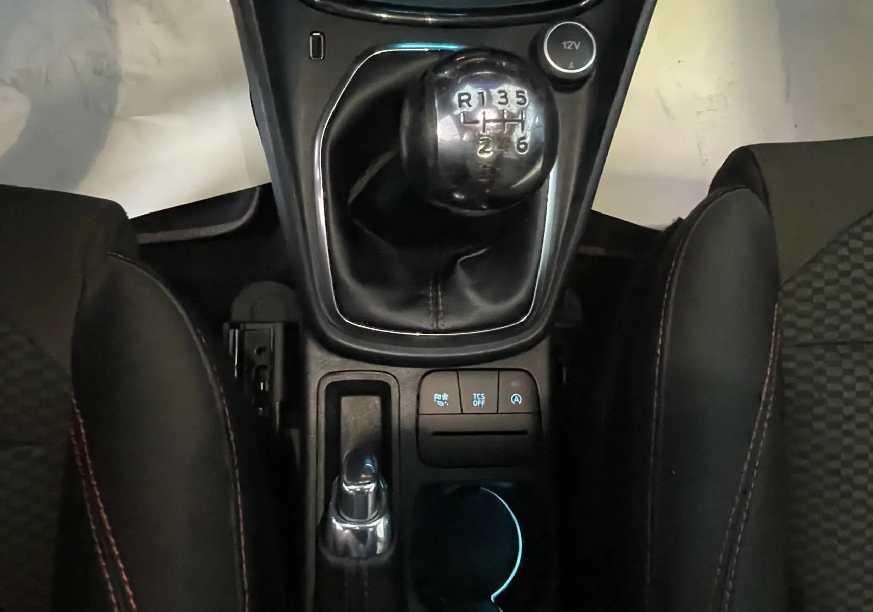 Vue rapprochée de la console centrale du Ford Puma 1.5 EcoBlue 2020, avec levier de vitesses manuel et sièges noirs.