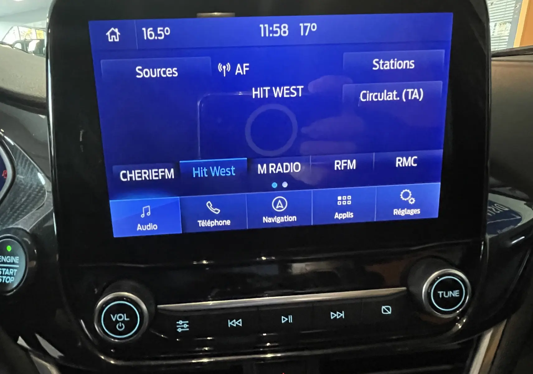 Écran tactile central du Ford Puma 1.5 EcoBlue gris 2020 affichant la radio Hit West et commandes audio.