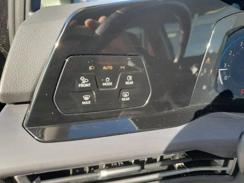 Gros plan sur les commandes d'éclairage et désembuage du tableau de bord noir de la Volkswagen Golf 1.5 eTSI 2021.