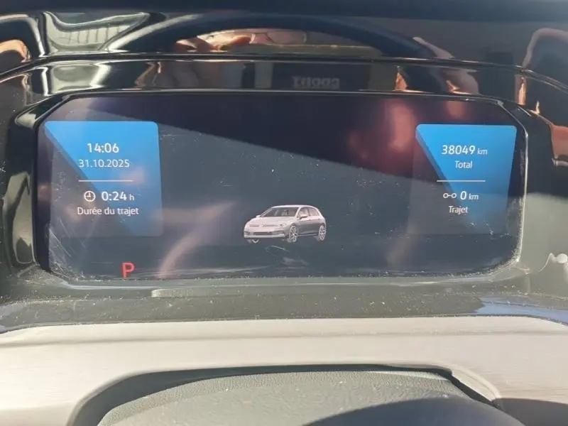 Tableau de bord numérique de Volkswagen Golf noir, affichant une vue stylisée du véhicule et les données de trajet.