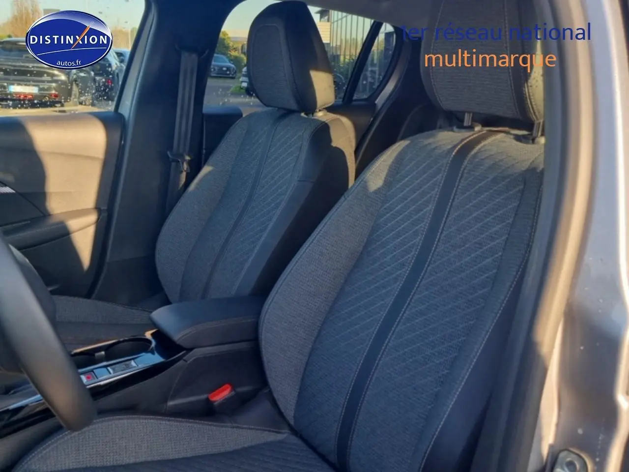 Vue intérieure côté conducteur montrant les sièges tissu gris de la Peugeot 208 1.2 100 Allure 2025.