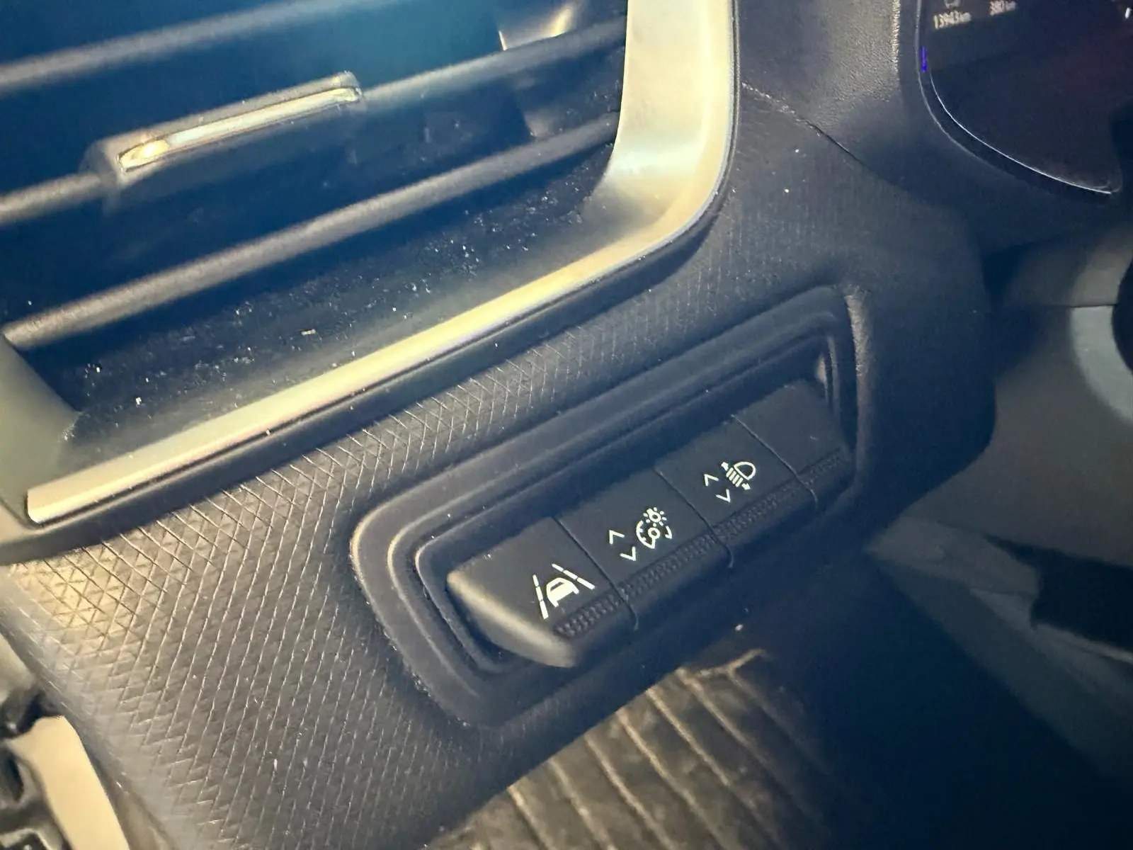 Gros plan sur les commandes d'aide à la conduite sur la console côté conducteur d'une Renault Clio gris platine 2023.