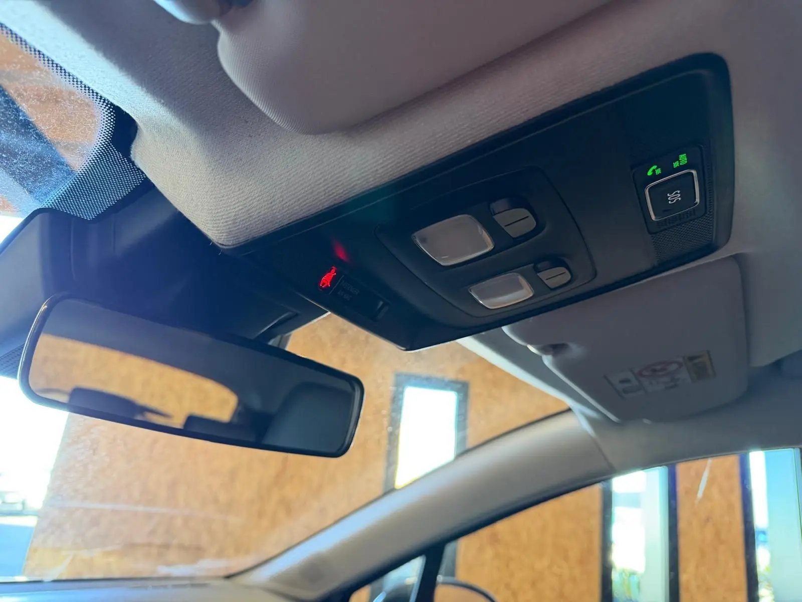 Vue intérieure du plafonnier et du rétroviseur d’une Renault Clio 2023, avec commandes d’éclairage et appel d’urgence.