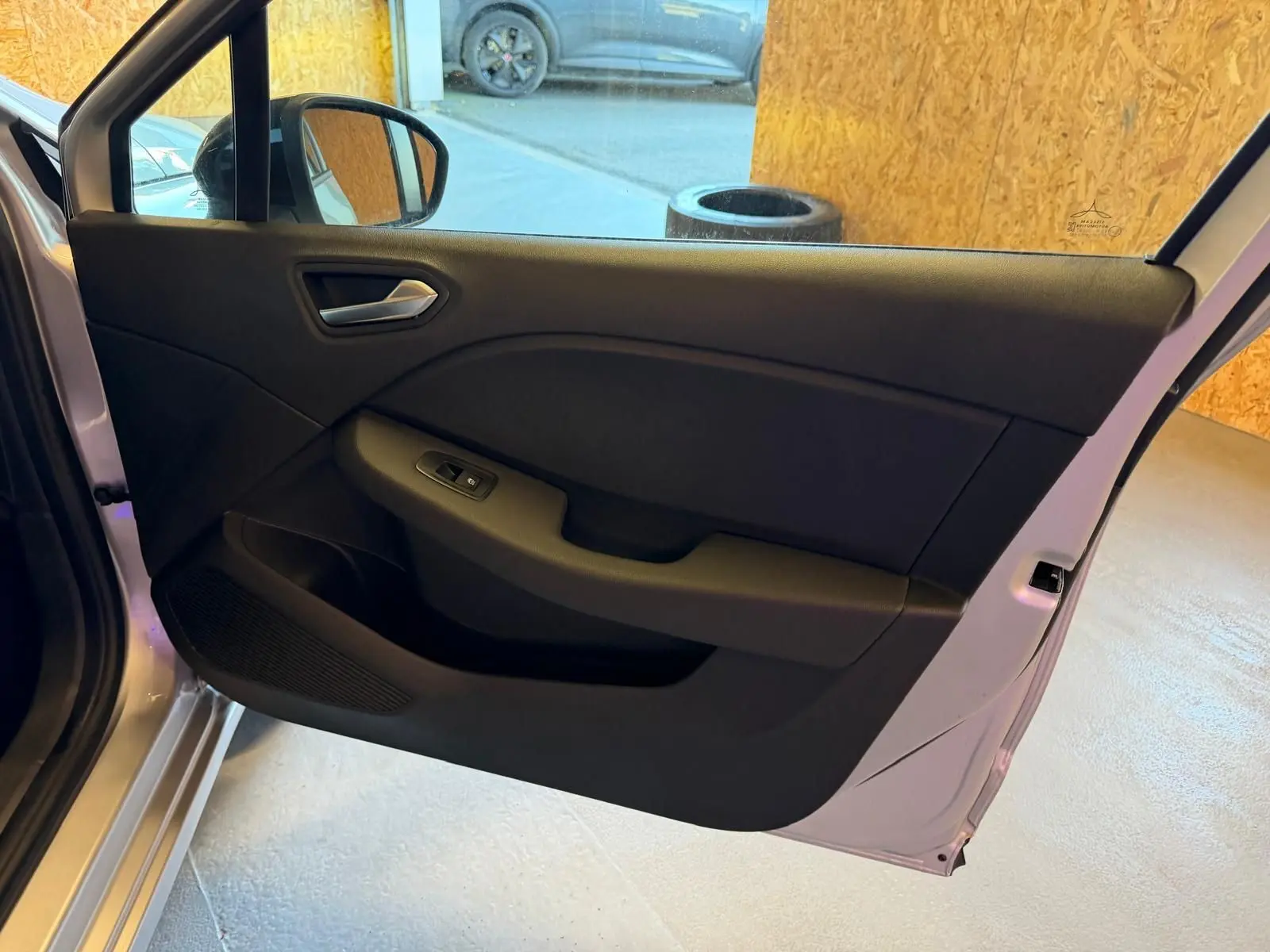 Vue intérieure de la porte arrière gauche gris platine de la Renault Clio 2023 avec commande de vitre électrique.