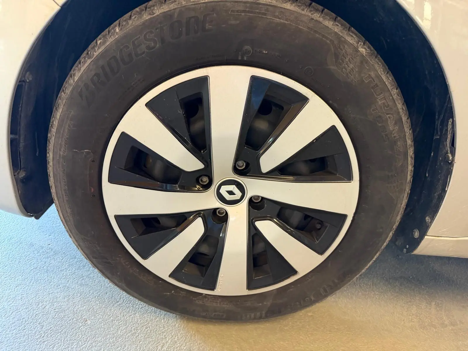 Gros plan sur la roue avant gauche de la Renault Clio gris platine avec jante alliage noire et argent.