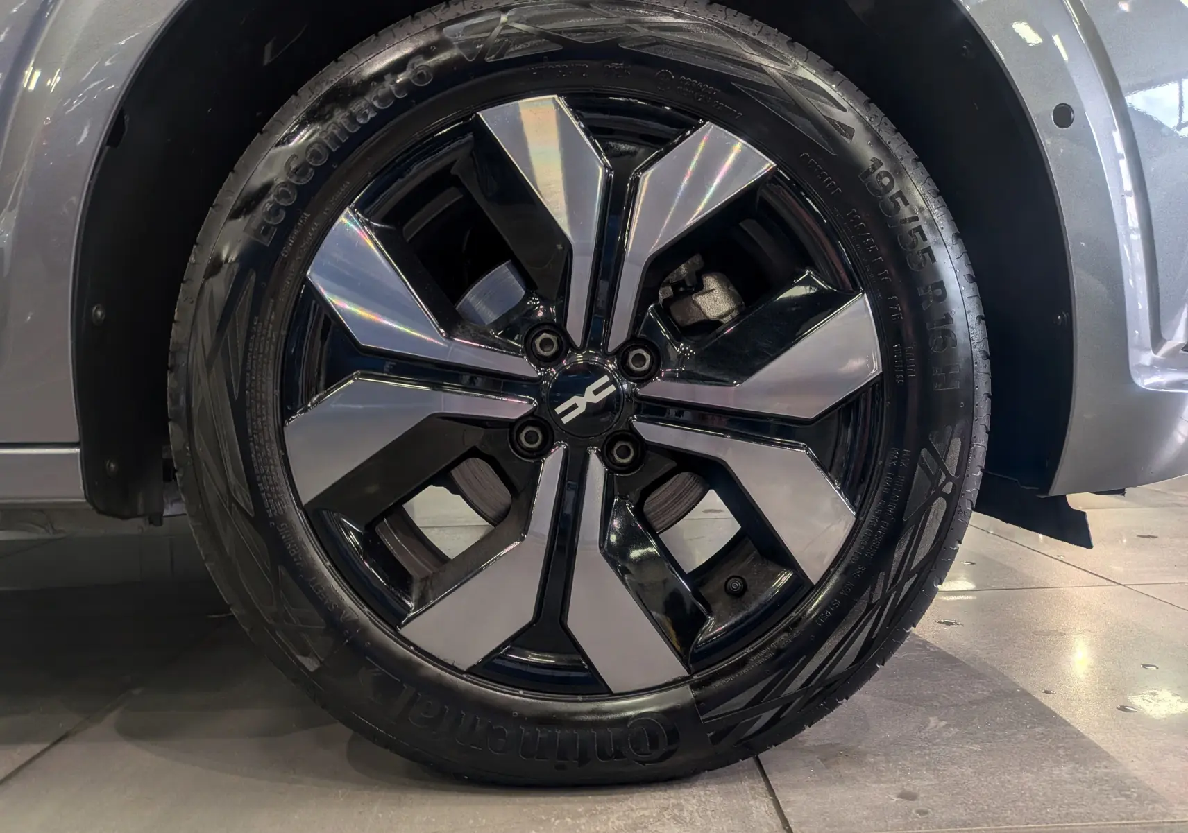 Gros plan sur la roue avant droite de la Dacia Sandero 2025 gris schiste, jante alliage bicolore distinctive.