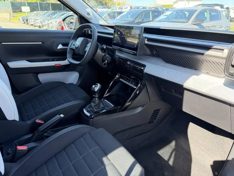 Vue intérieure côté conducteur de la Citroën C3 1.2 Turbo 100ch MAX 2025 avec tableau de bord moderne et boîte manuelle.