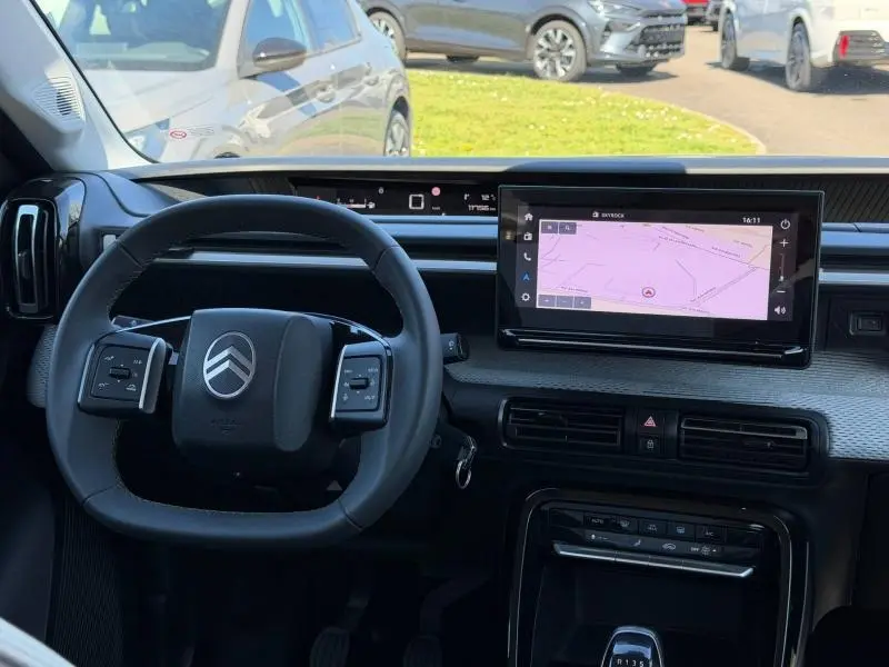 Vue intérieure frontale du tableau de bord de la Citroën C3 2025 avec écran tactile et volant multifonction noir.
