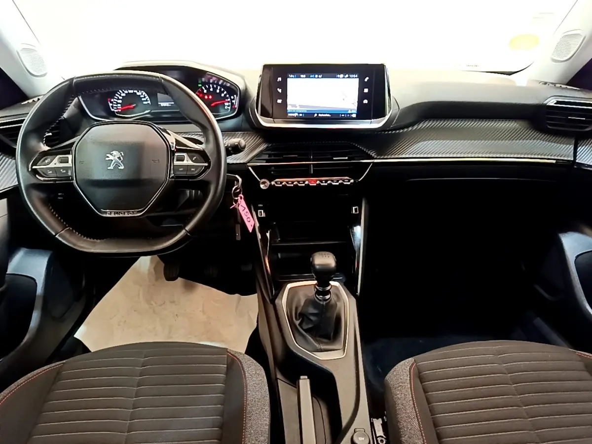 Vue intérieure avant du Peugeot 2008 2021, tableau de bord noir avec écran tactile et volant cuir multifonctions.