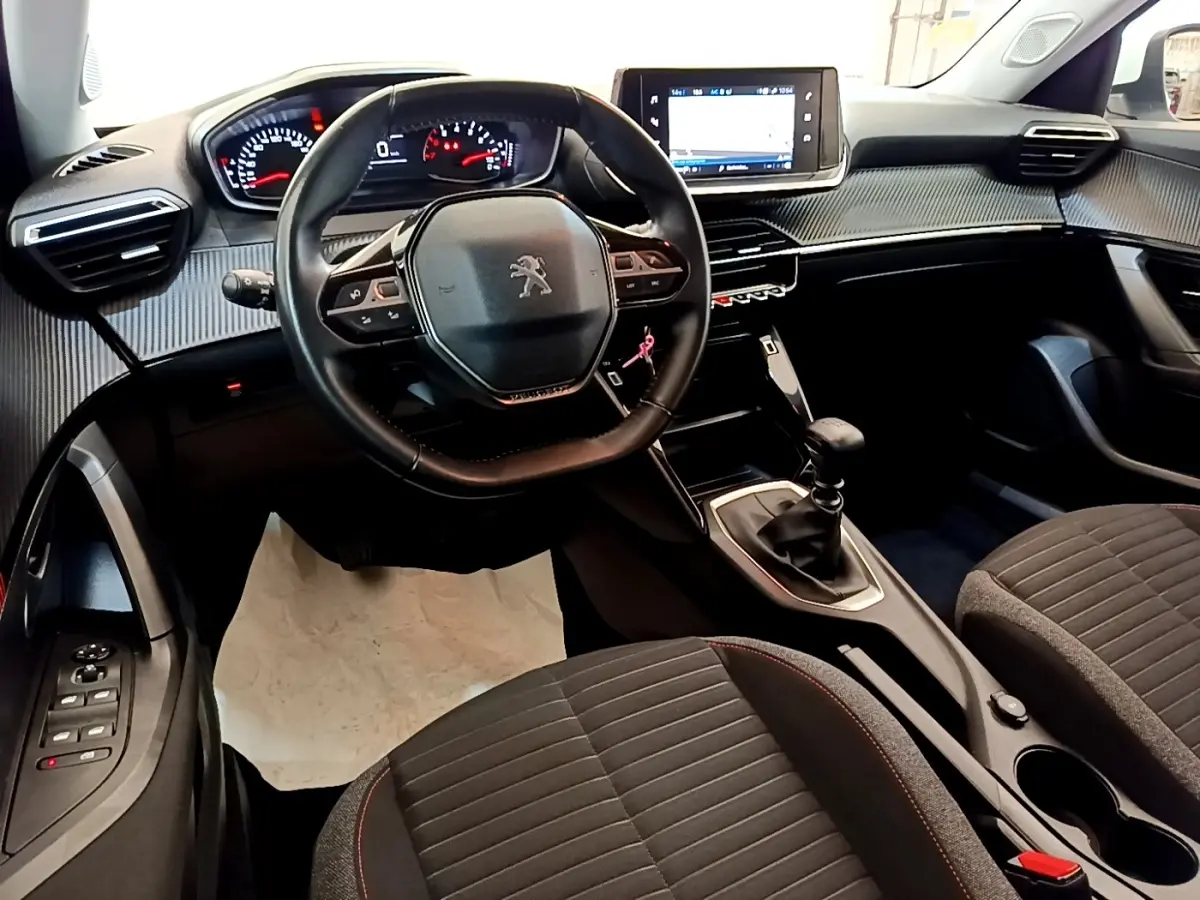 Vue intérieure avant du Peugeot 2008 avec volant cuir multifonctions, tableau de bord numérique et levier de vitesses manuel.