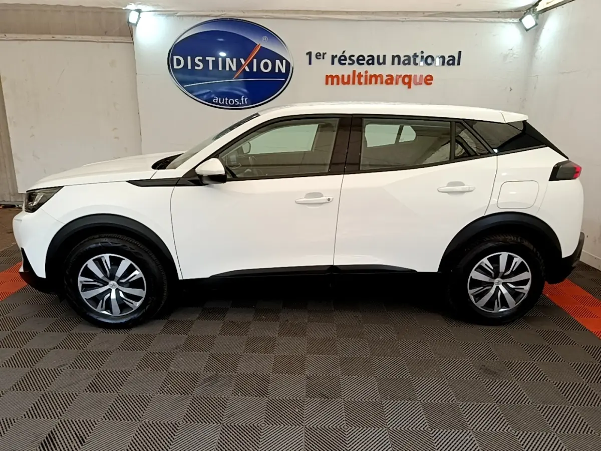 Peugeot 2008 blanc vue de profil côté gauche, avec jantes alliage et détails noirs contrastants.