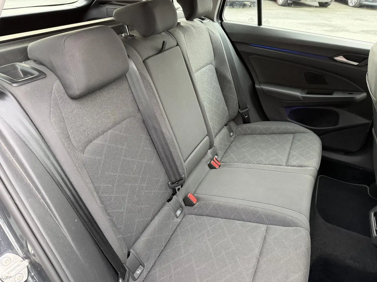 Vue intérieure côté droit de la banquette arrière grise en tissu de la Volkswagen Golf SW 2022 avec accoudoir central rabattable.