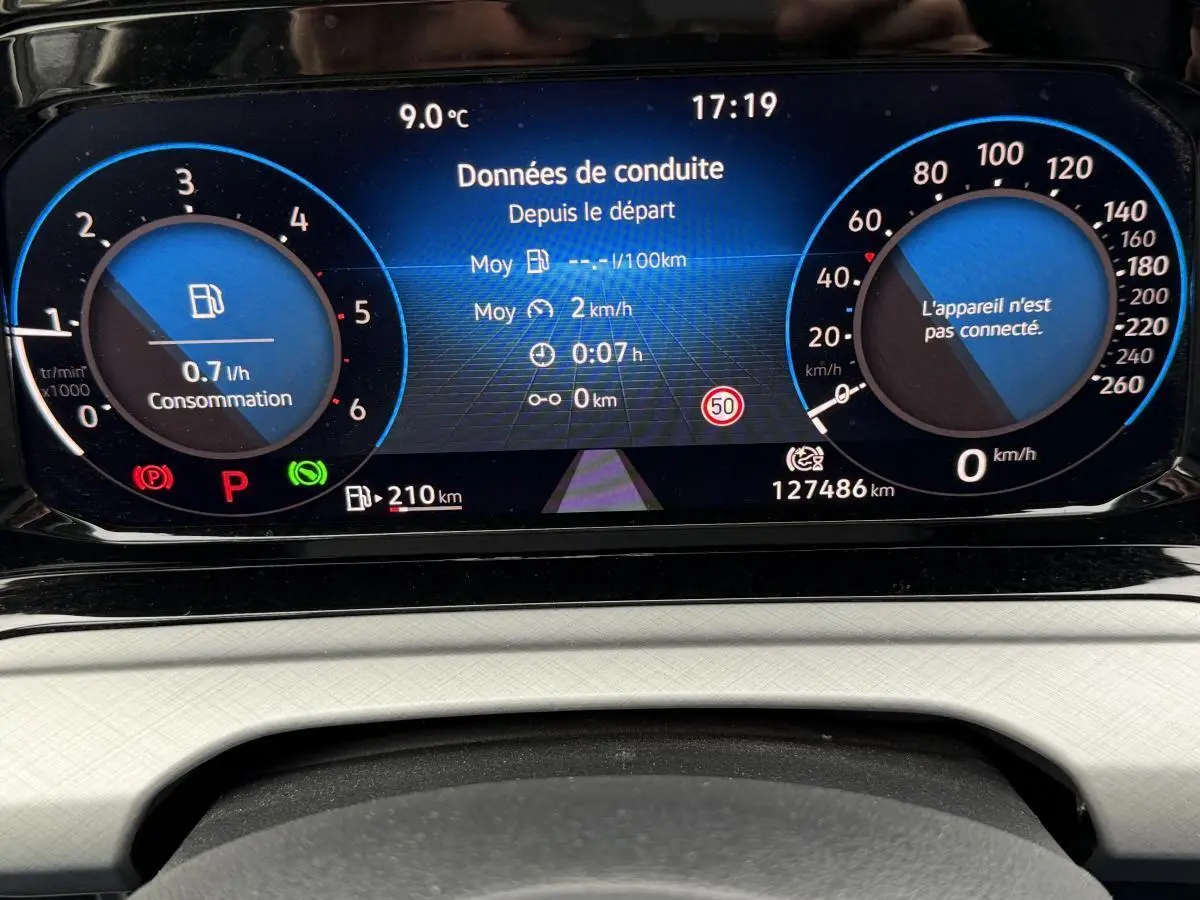 Vue rapprochée du tableau de bord digital bleu et noir de la Volkswagen Golf SW 2.0 TDI 2022 affichant données de conduite.