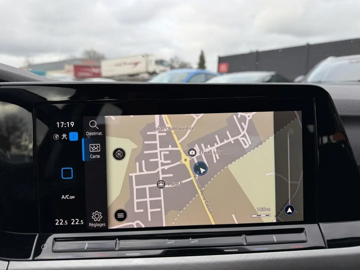 Vue intérieure sur l'écran tactile central du système de navigation d'une Volkswagen Golf gris, avec carte affichée.