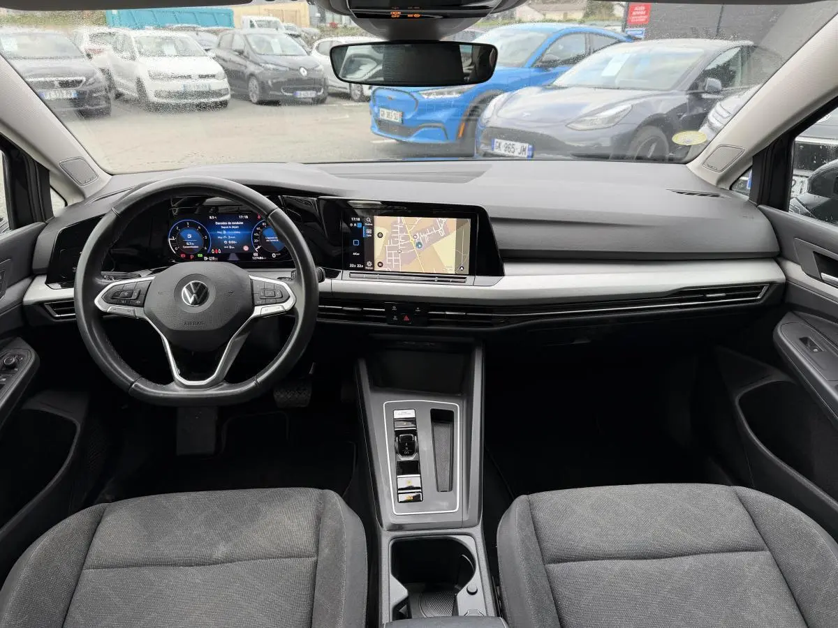 Vue intérieure avant de la Volkswagen Golf SW 2.0 TDI gris, avec tableau de bord digital et écran tactile central.
