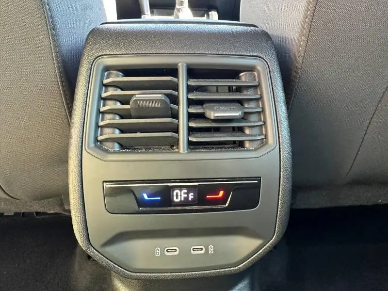 Gros plan sur la console arrière du SEAT LEON ST 2025, montrant les aérateurs et commandes de climatisation avec ports USB.