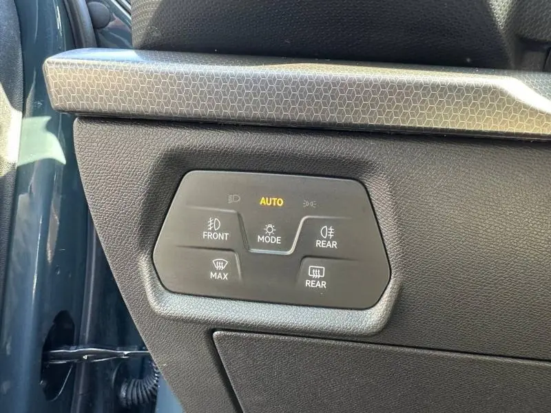 Détail du panneau de commandes d’éclairage intérieur côté gauche d’un SEAT LEON ST bleu saphir métallisé, avec mode automatique activé.