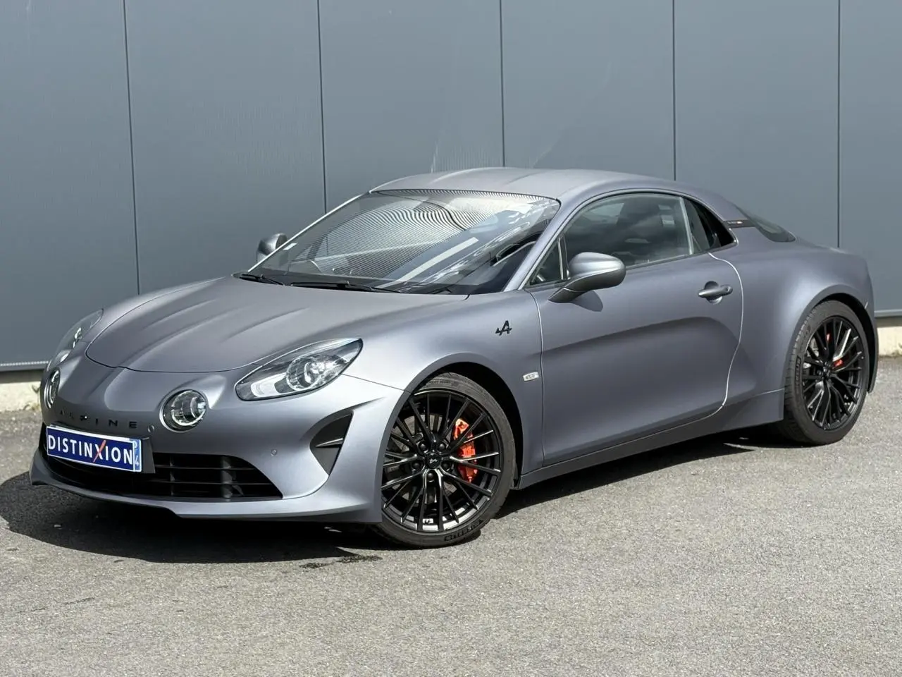 Alpine A110 1.8T 292 S gris Tonnerre Mat vue 3/4 avant avec jantes noires et étriers de frein orange.