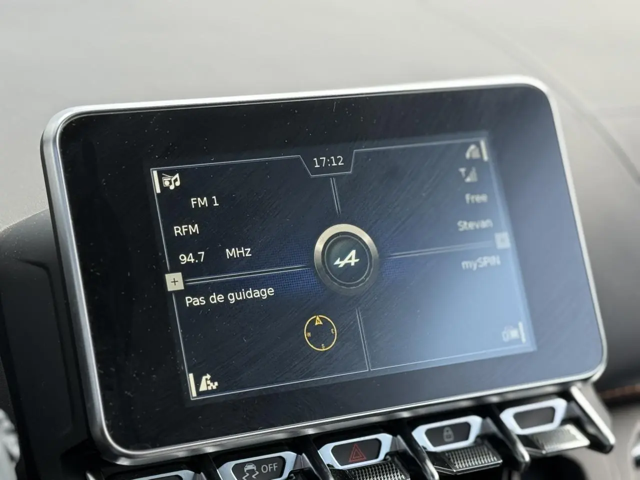 Écran tactile central de l'Alpine A110 1.8T 292 S affichant la radio FM et le logo Alpine, vue rapprochée intérieure.