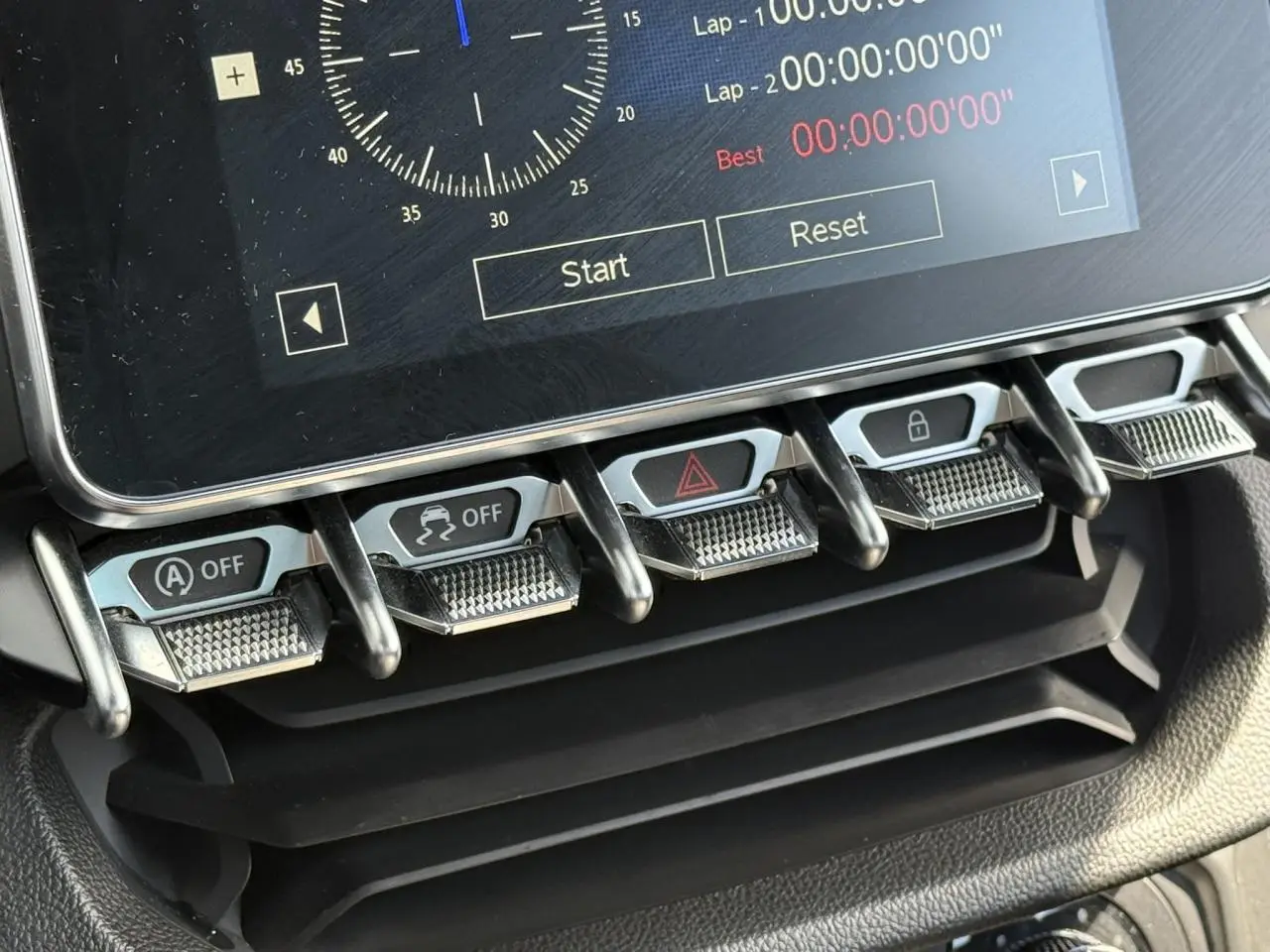 Gros plan sur les commandes en métal brossé sous l'écran tactile de l'Alpine A110 Gris Tonnerre Mat, version 2020.