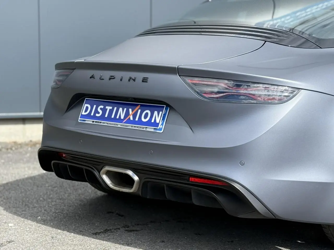 Vue arrière rapprochée de l'Alpine A110 1.8T 292 S gris tonnerre mat avec diffuseur noir et sortie d'échappement hexagonale.