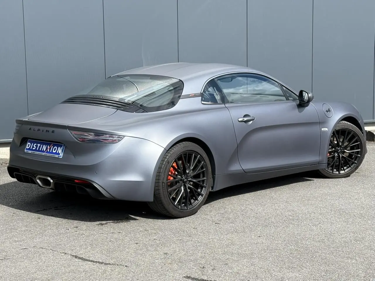 Vue 3/4 arrière droite de l'Alpine A110 1.8T 292 S gris Tonnerre mat avec jantes noires et étriers orange.