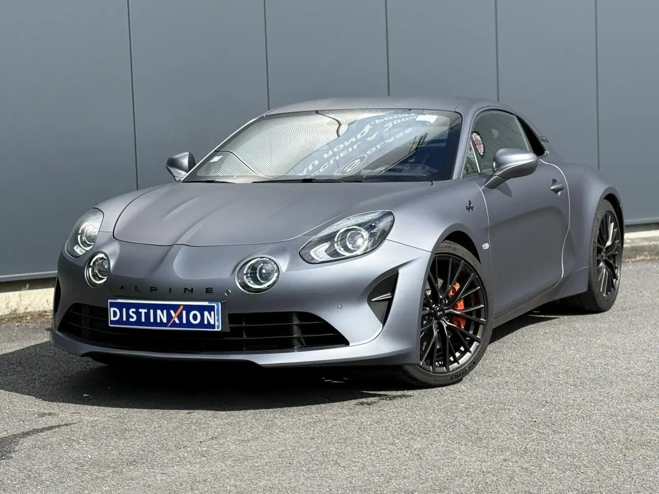 Alpine A110 1.8T 292 S gris Tonnerre Mat vue 3/4 avant avec jantes noires et étriers de frein orange.