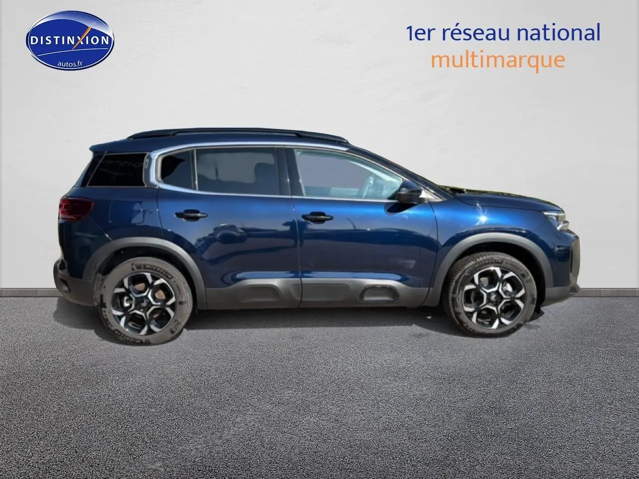 Profil droit d'un Citroën C5 Aircross bleu eclipse 2025 avec barres de toit et jantes alu distinctives.
