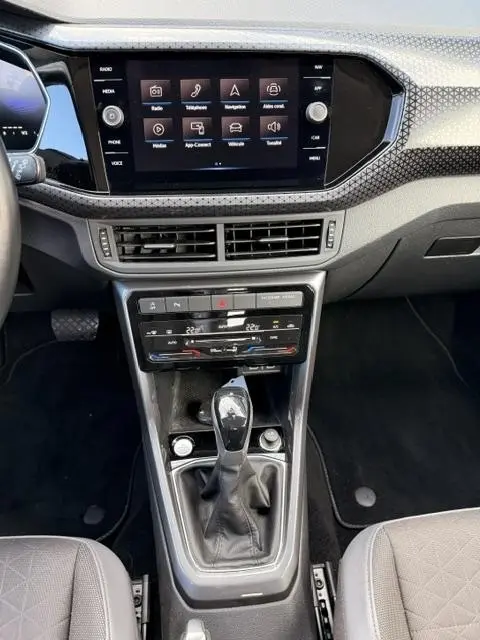 Vue plongeante sur la console centrale et l'écran tactile du Volkswagen T-Cross gris foncé 1.0 TSI R-Line Tech 2023.