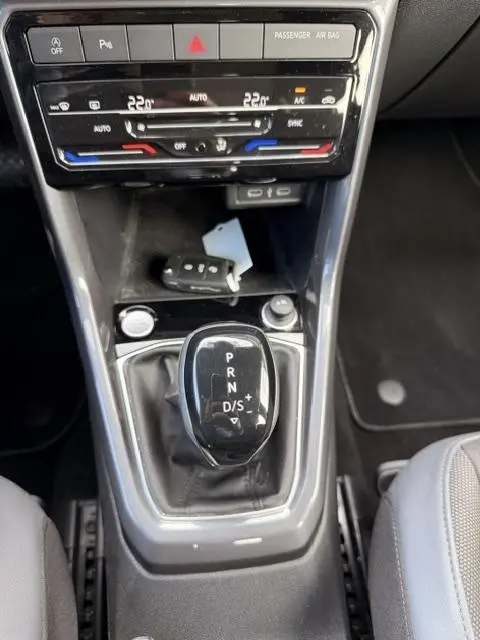 Gros plan sur le levier de vitesses automatique noir et la console centrale grise du Volkswagen T-Cross 1.0 TSI R-Line 2023.