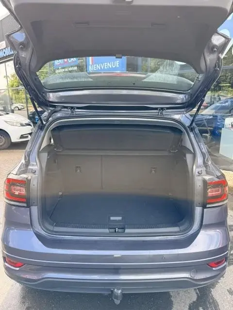Vue arrière du Volkswagen T-Cross gris foncé 2023 avec coffre ouvert et hayon relevé, montrant l'espace de chargement vide.