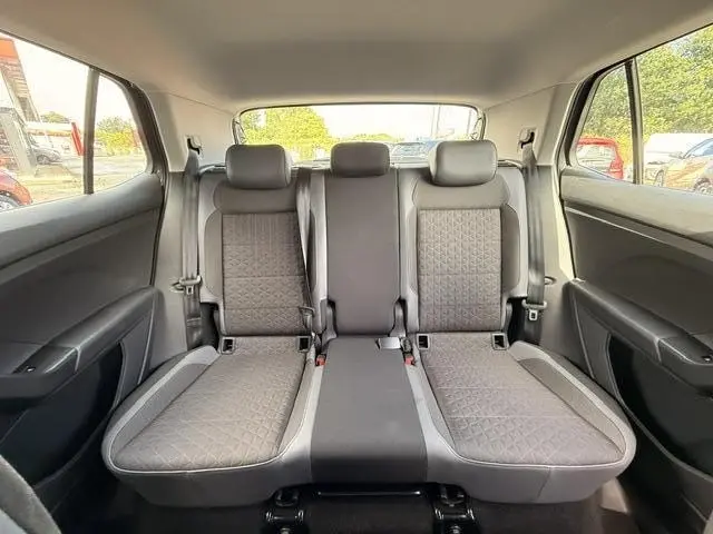 Vue intérieure arrière du Volkswagen T-Cross gris foncé 2023, montrant la banquette arrière trois places en tissu Hexalink.