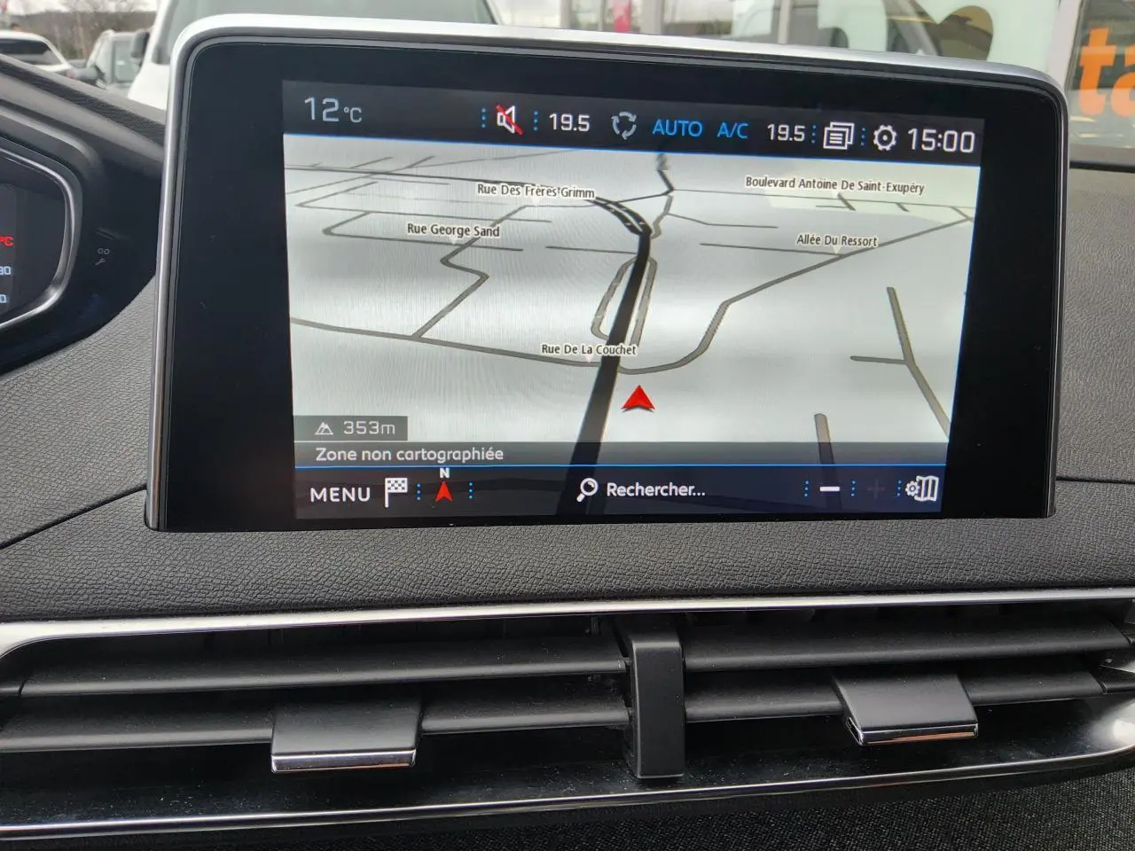 Écran tactile du système de navigation Peugeot i-Cockpit affichant une carte, tableau de bord noir.