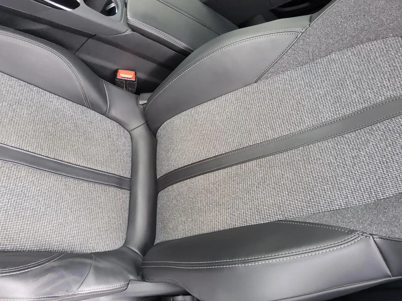 Gros plan sur la sellerie TEP et tissu gris à motifs du siège avant droit du Peugeot 3008 rouge foncé.