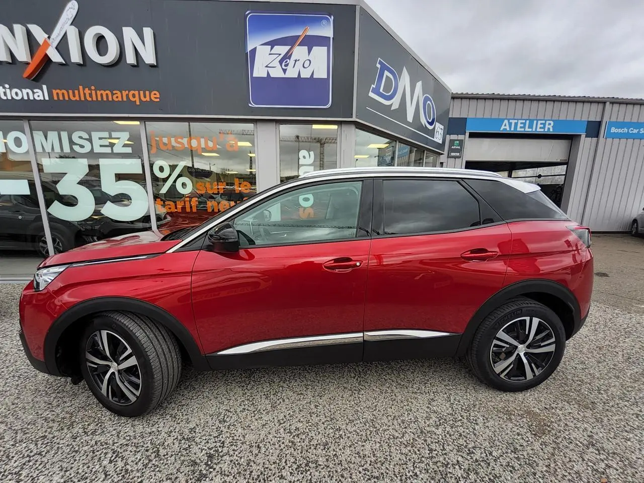 Vue de profil côté gauche d’un Peugeot 3008 rouge foncé avec toit blanc et jantes alliage bi-ton.