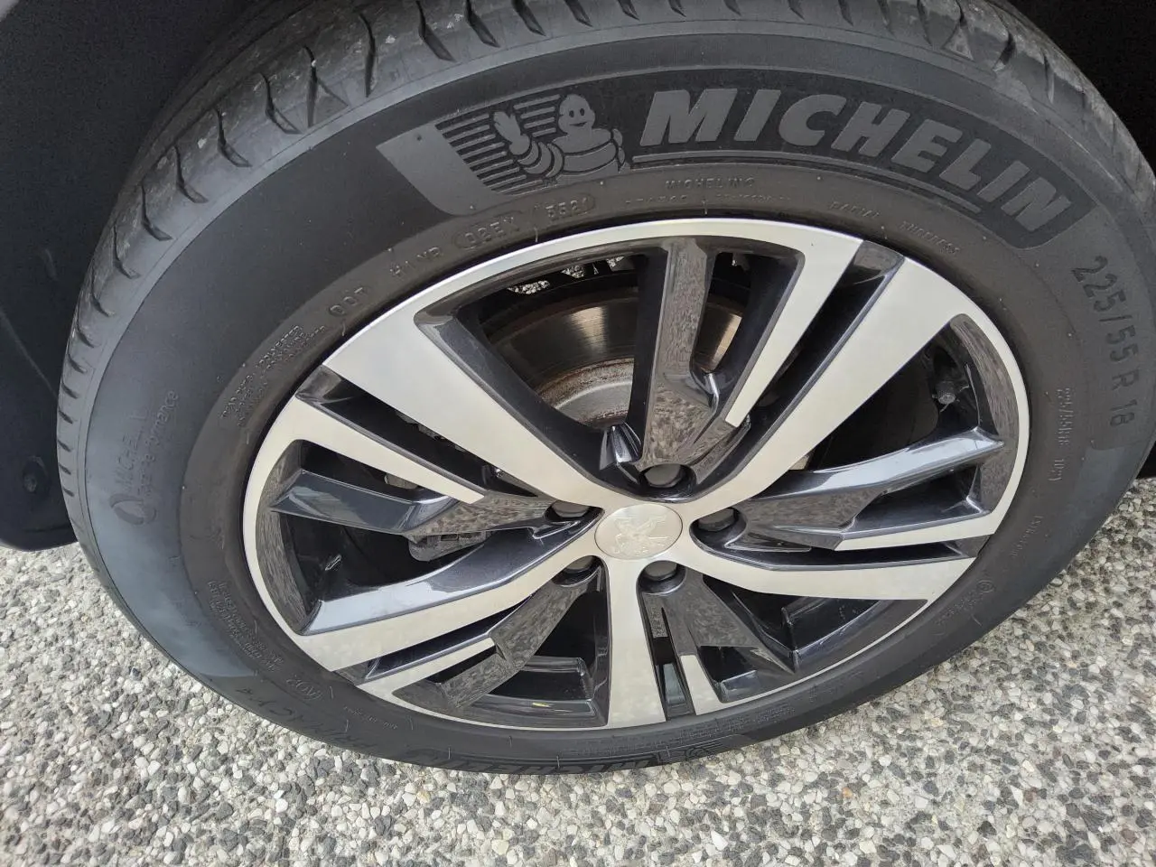 Gros plan sur la jante alliage 18 pouces bi-ton diamantée d’un Peugeot 3008 rouge foncé, pneu Michelin visible.