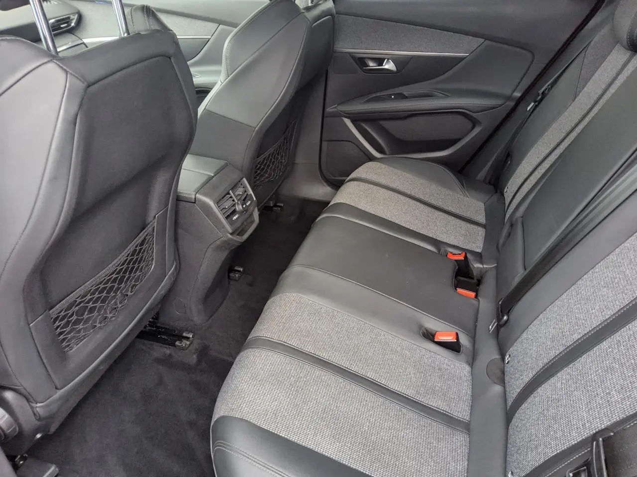 Vue arrière côté droit de l’habitacle du Peugeot 3008 avec banquette bi-matière gris et noir et aérateurs centraux.
