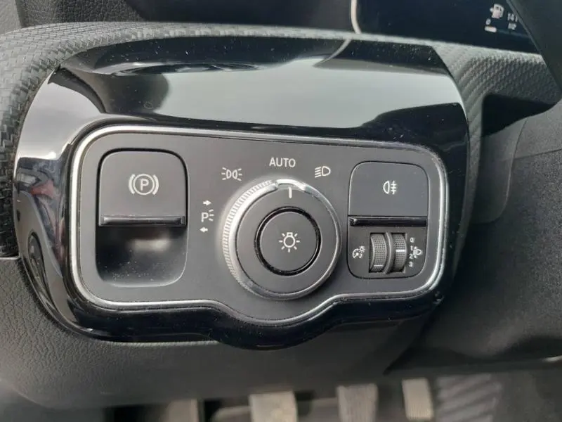 Gros plan sur la commande des feux et frein de stationnement dans l'habitacle d'une Mercedes Classe A gris montagne métallisé 2018.