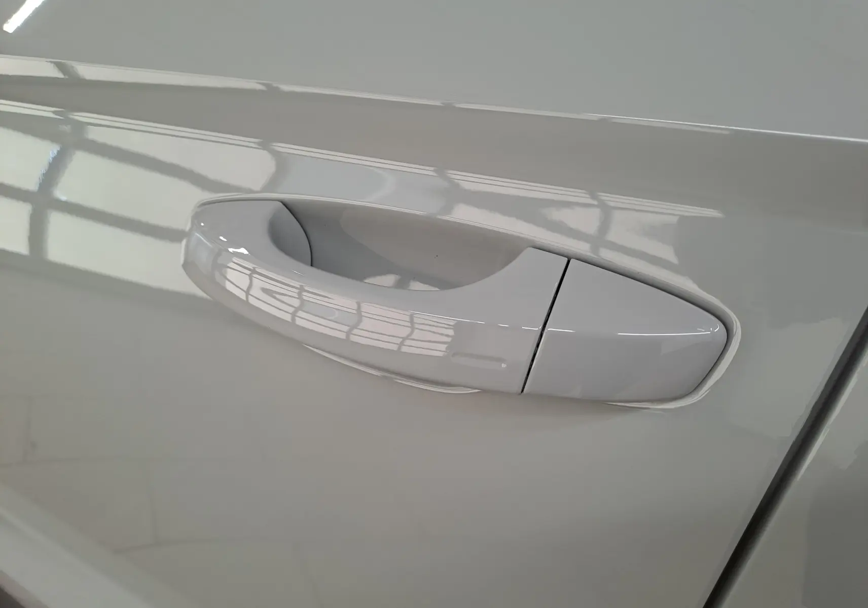 Poignée de porte côté droit du Skoda Karoq gris perle 2023, finition lisse et intégrée à la carrosserie.