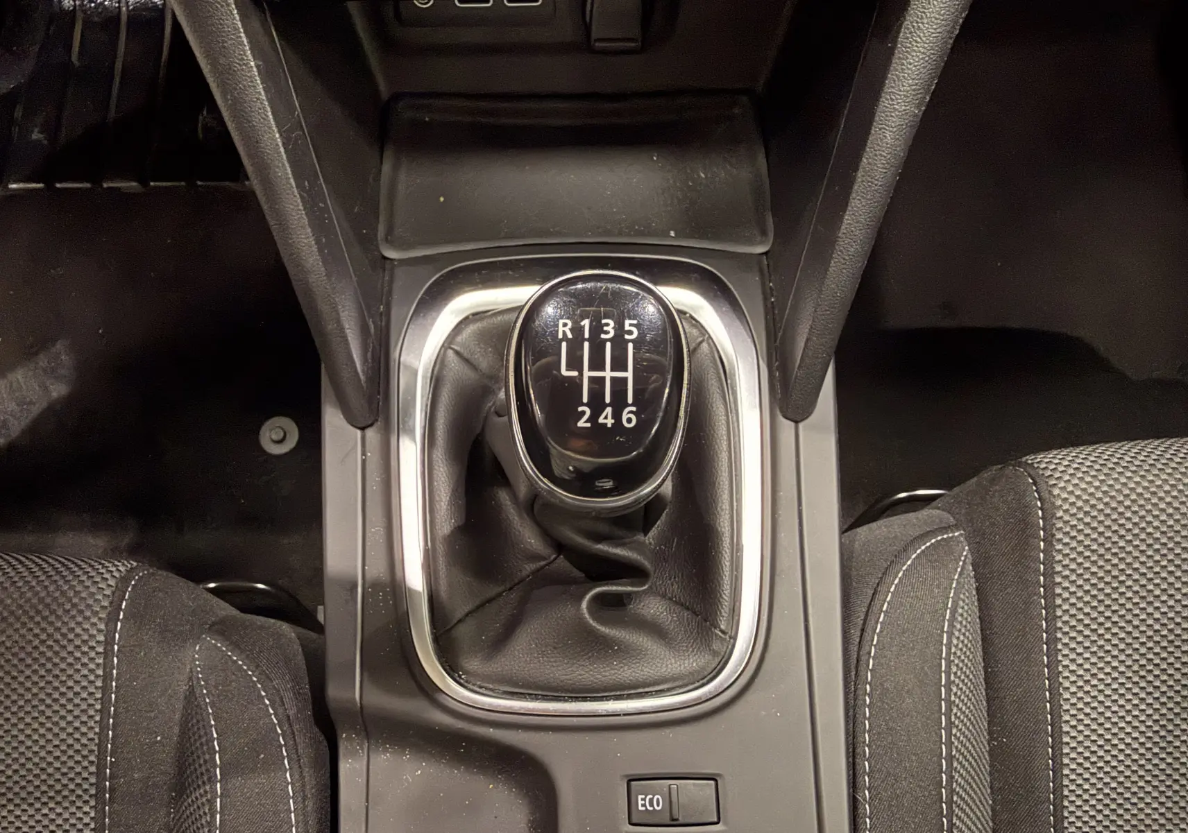 Vue rapprochée du levier de vitesses manuel noir de la Renault Mégane IV 1.5 dCi 115, avec sellerie tissu grise.