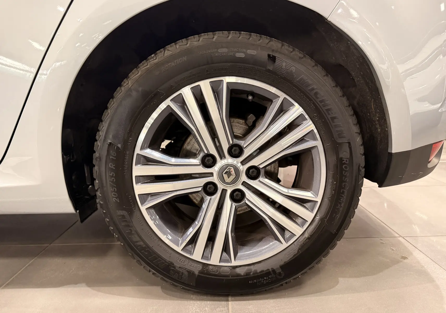 Gros plan sur la roue avant droite de la Renault Mégane IV gris Highland avec jante alliage à multiples branches.