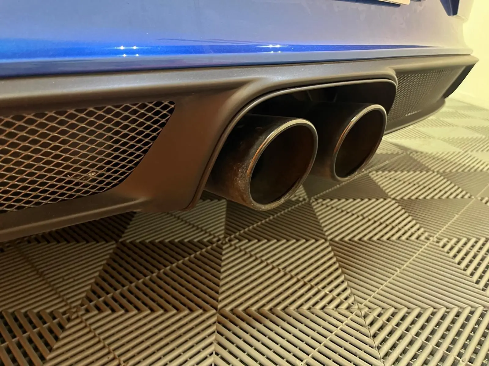 Gros plan sur la double sortie d’échappement arrière noire d’une Porsche 911 GT3 bleu saphir.